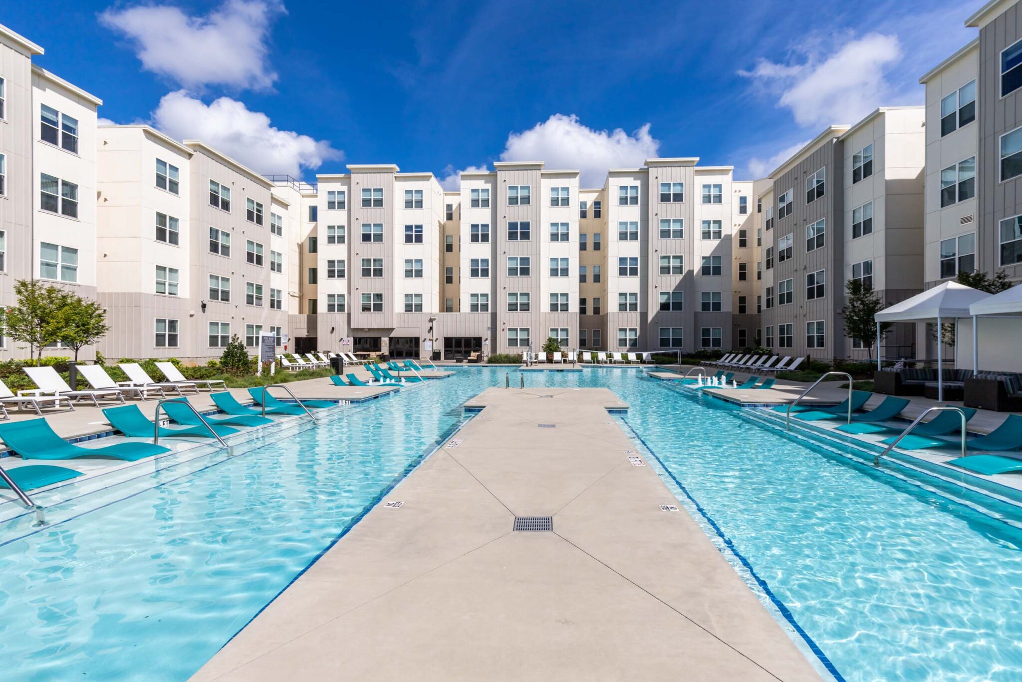 Outdoor Pool and Lounge Chairs Surrounded by Apartment Buildings