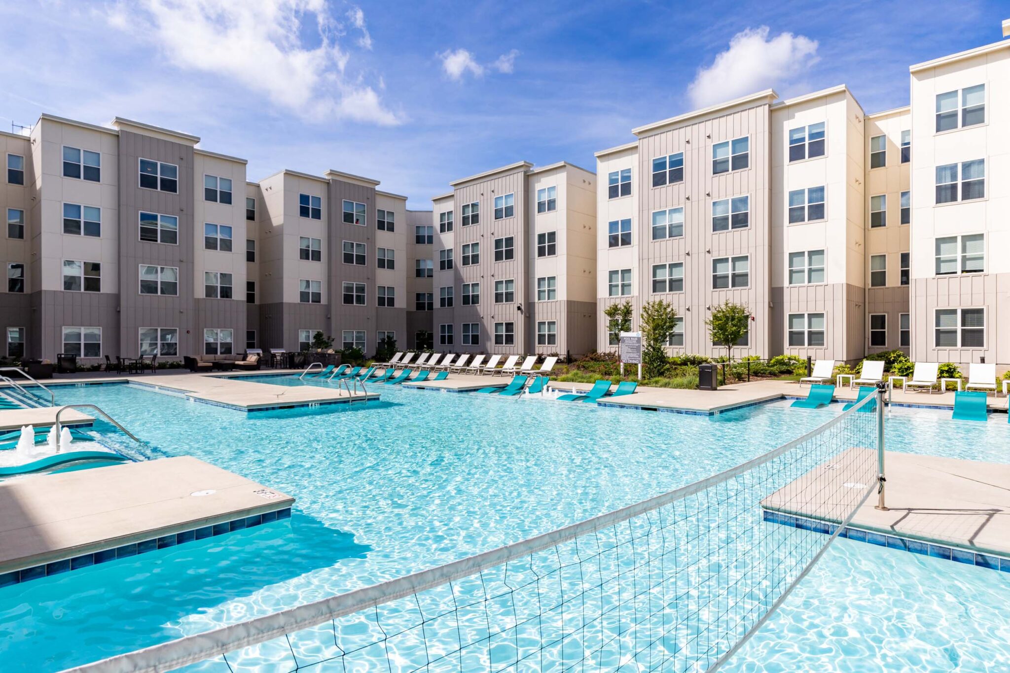 Scenic pool area with volleyball net in apartment complex